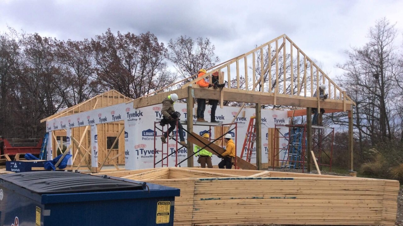 construction trades students work outside framing a house